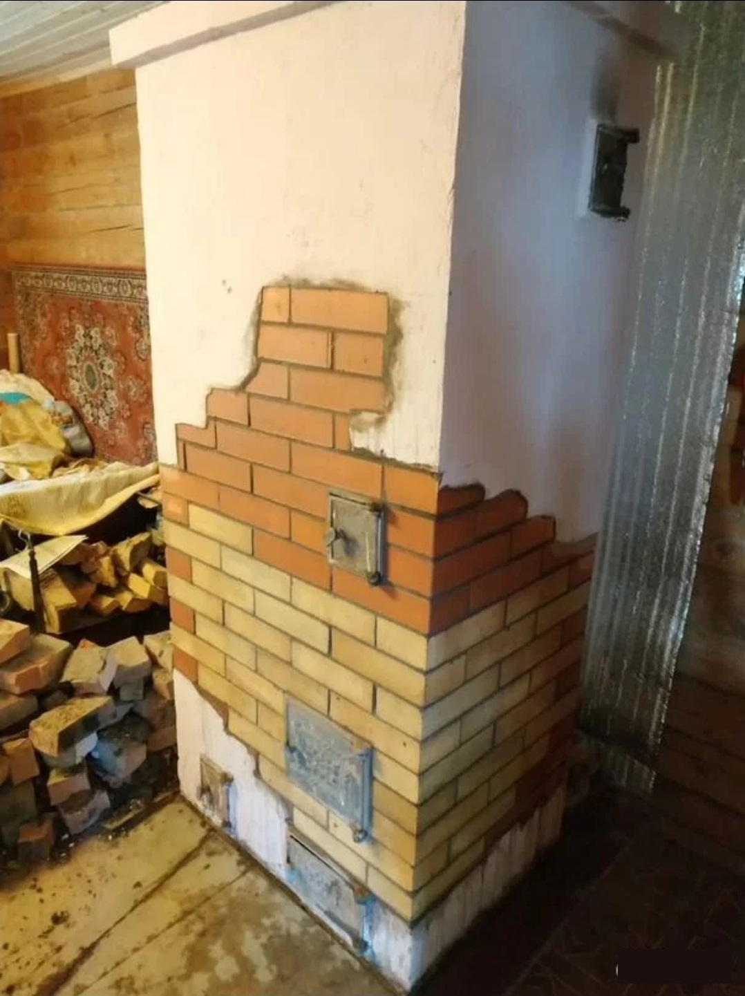 Печь в процессе облицовки кирпичом в жилой комнате